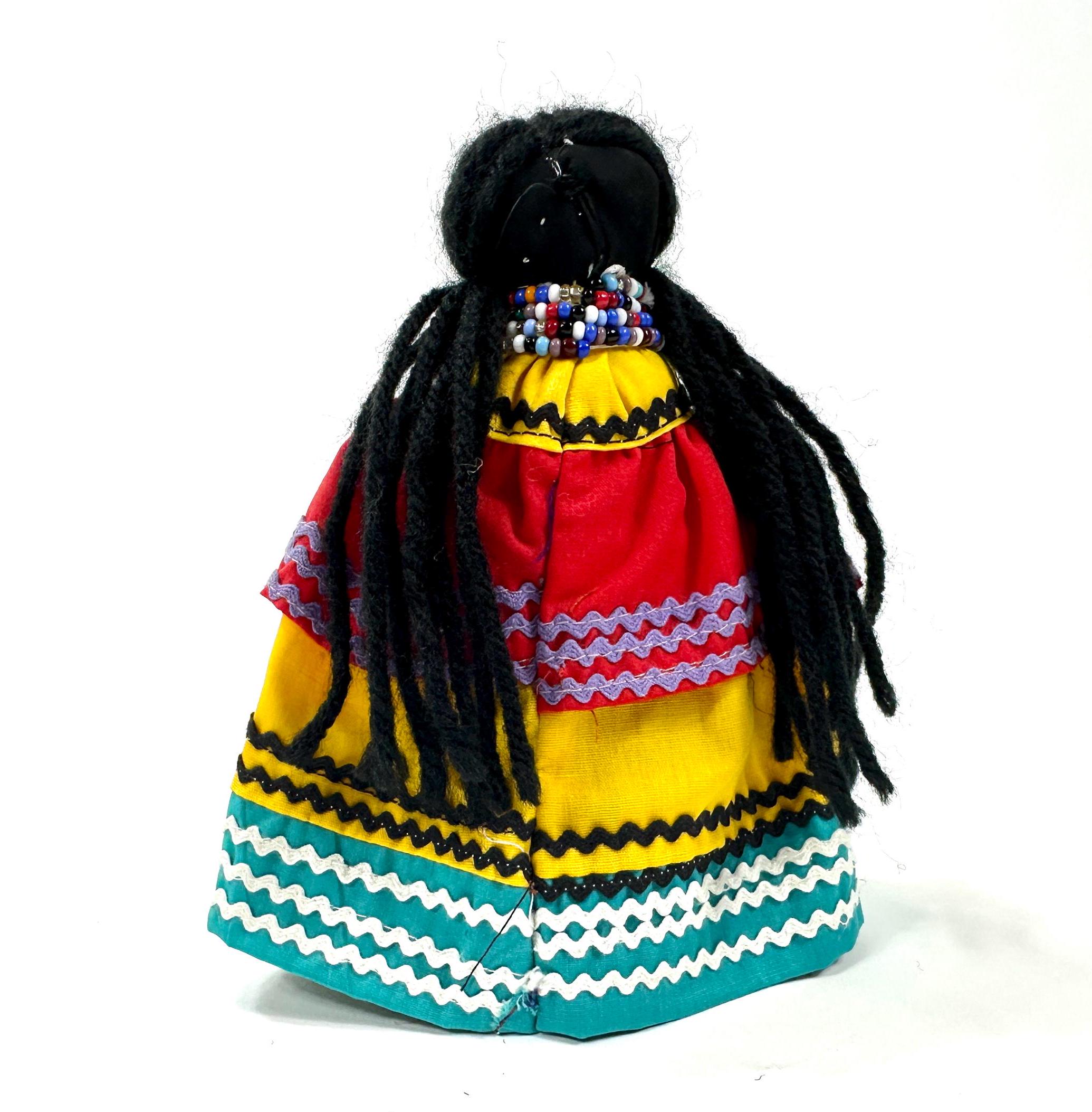 Angled view showing full doll silhouette with black hair against neutral background, emphasizing skirt volume and color gradi