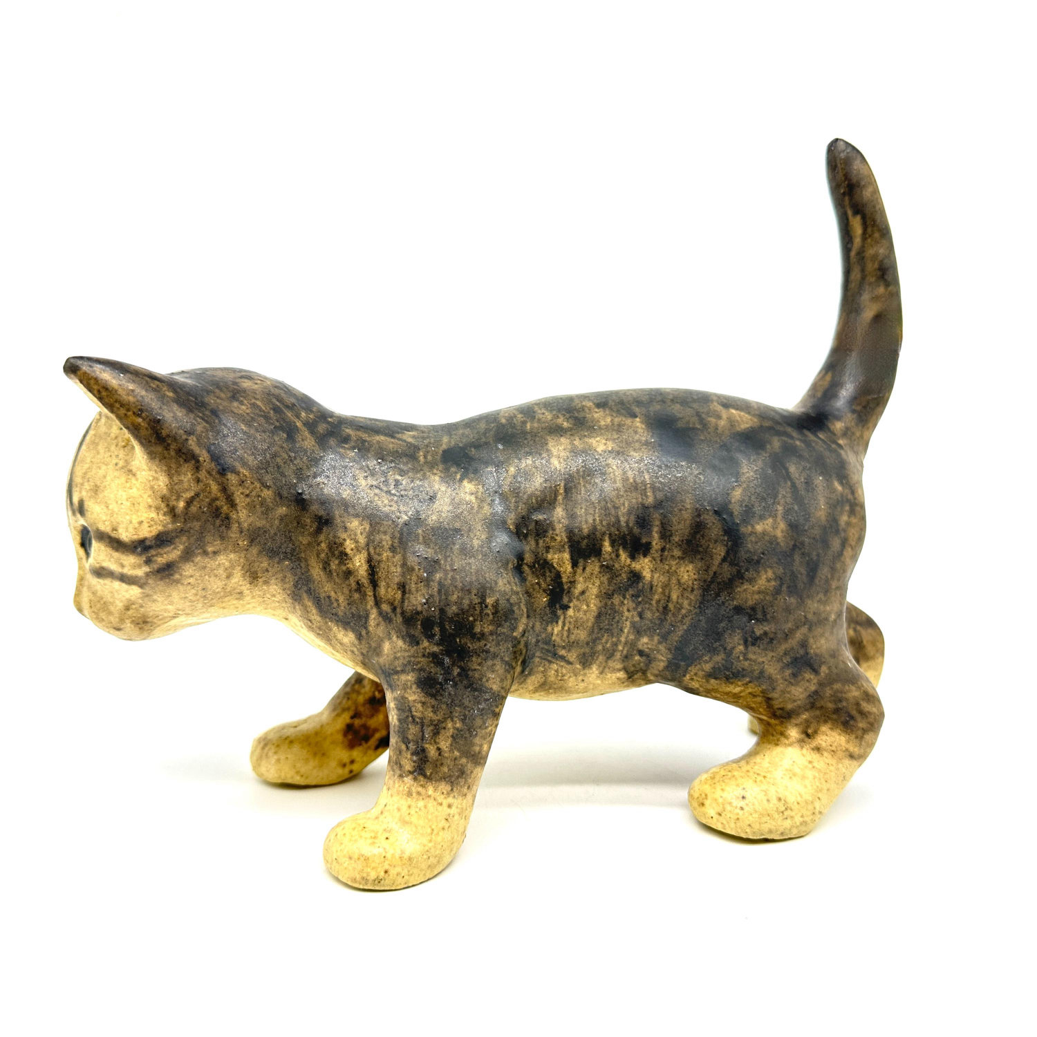 Ceramic tabby cat figurine in profile showing elongated body, extended tail, and hand-painted stripe details