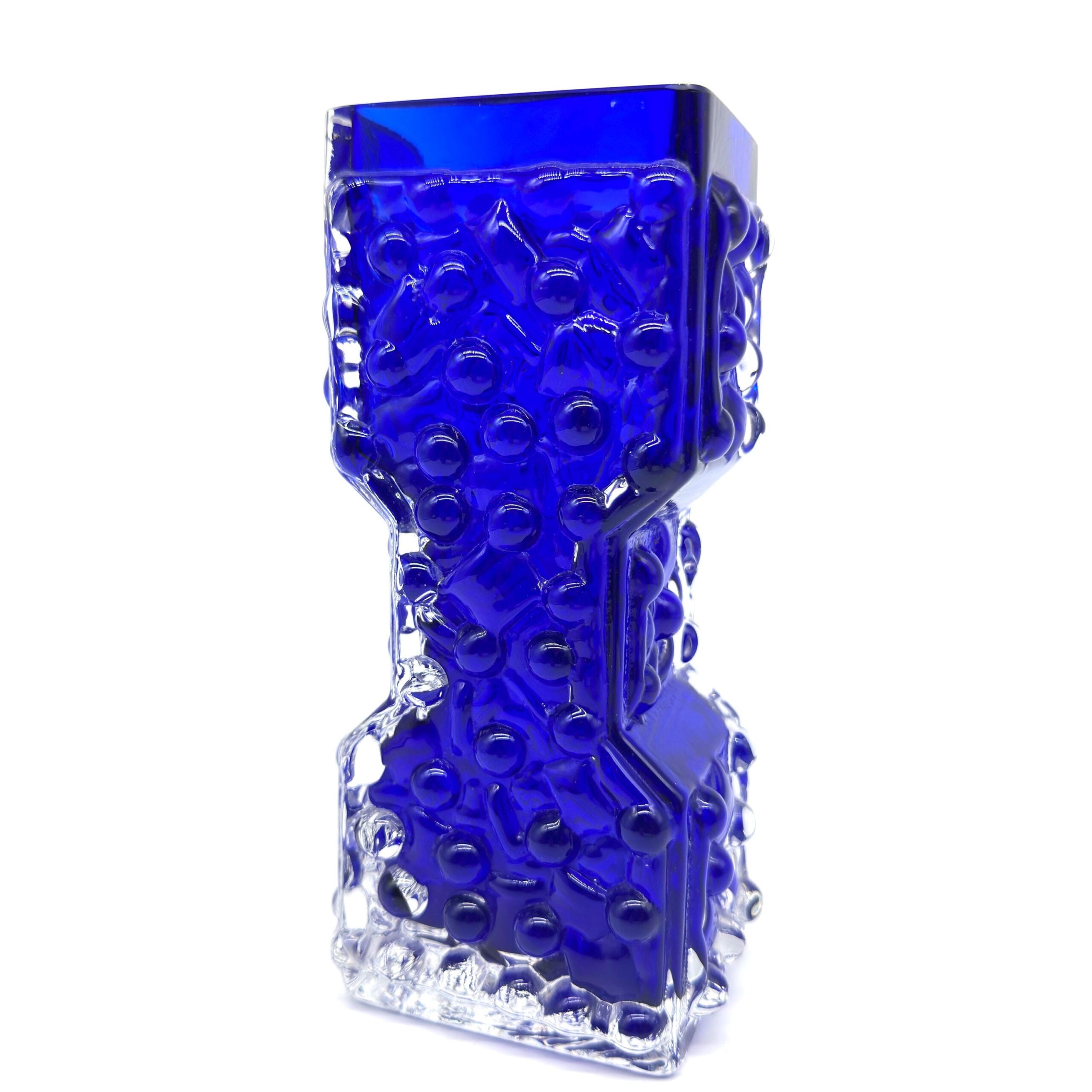 Cobalt vase textured body straight-on angle, hourglass proportion visible, clear glass base below bubble-patterned form
