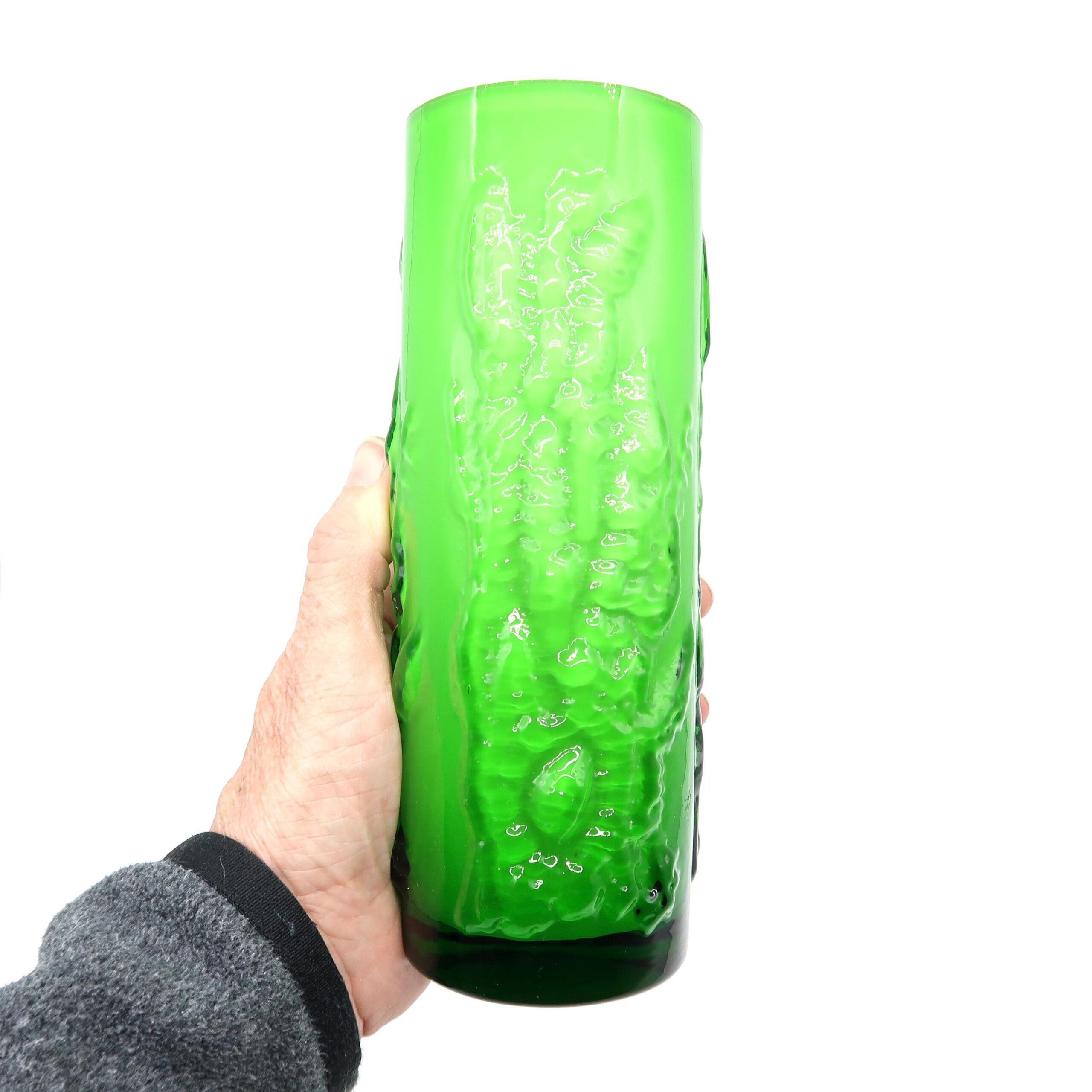 Eneryda green cased glass vase with bark texture, held in hand, showing vivid lime-green exterior and cylindrical form