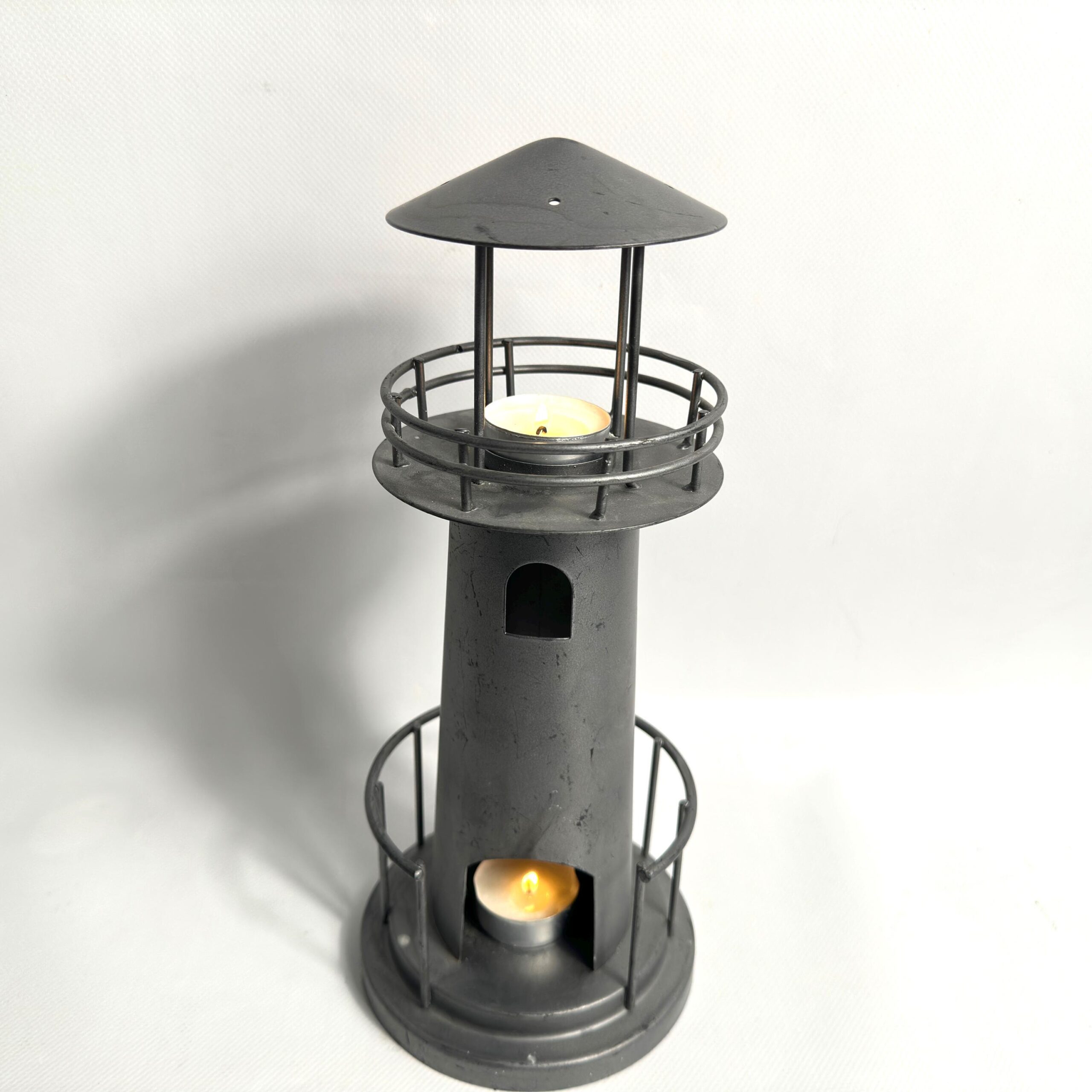 Final lighthouse view with upper and lower tealights burning, showcasing dual-light coastal ambiance design