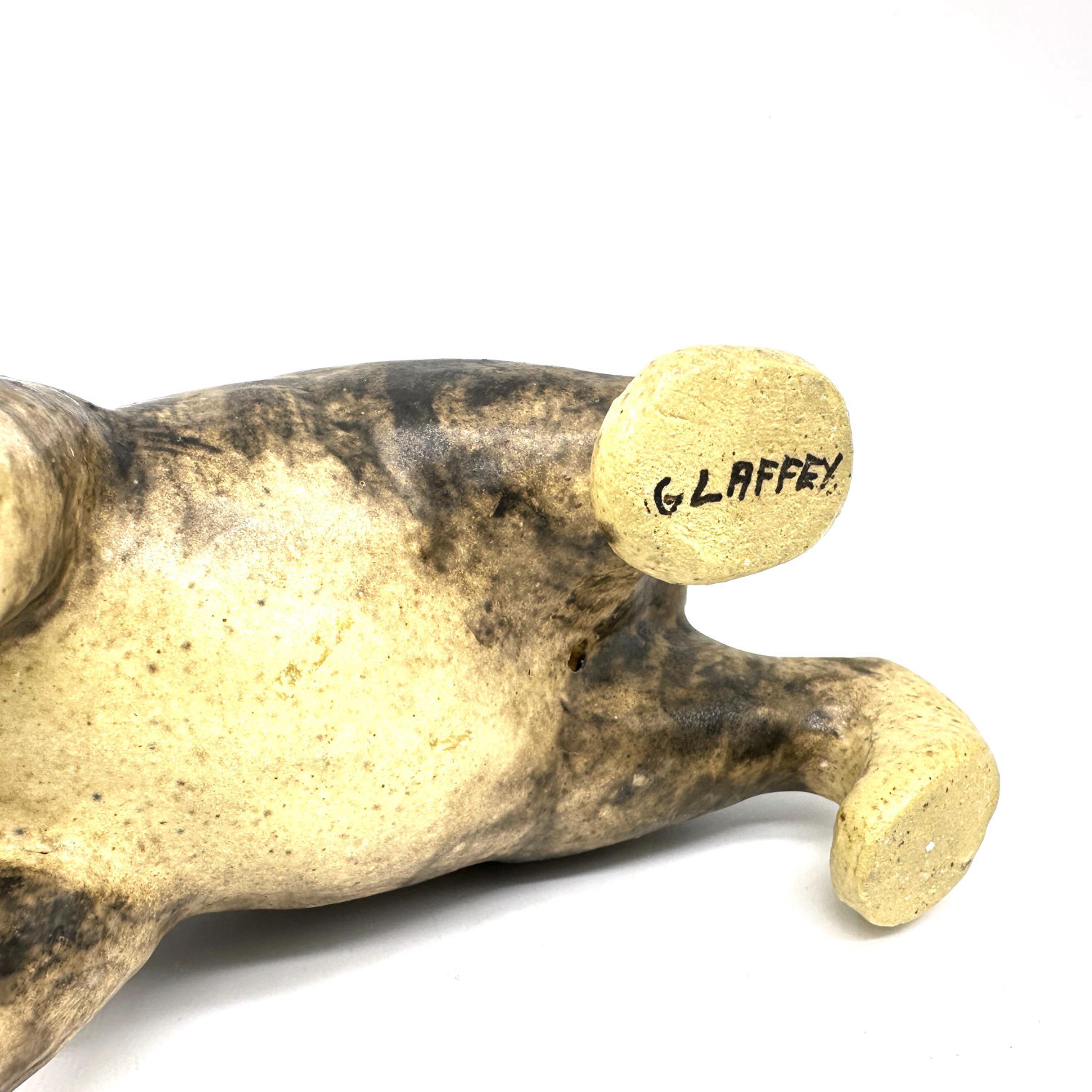 G. Laffey artist signature detail on ceramic cat sculpture's paw base, maker's mark visible