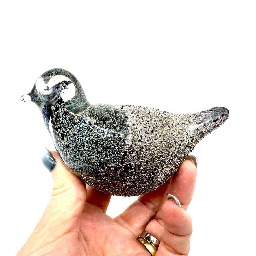 Jussis Finland art glass bird figurine from 1970s held in hand, featuring textured smoky grey body with polished head