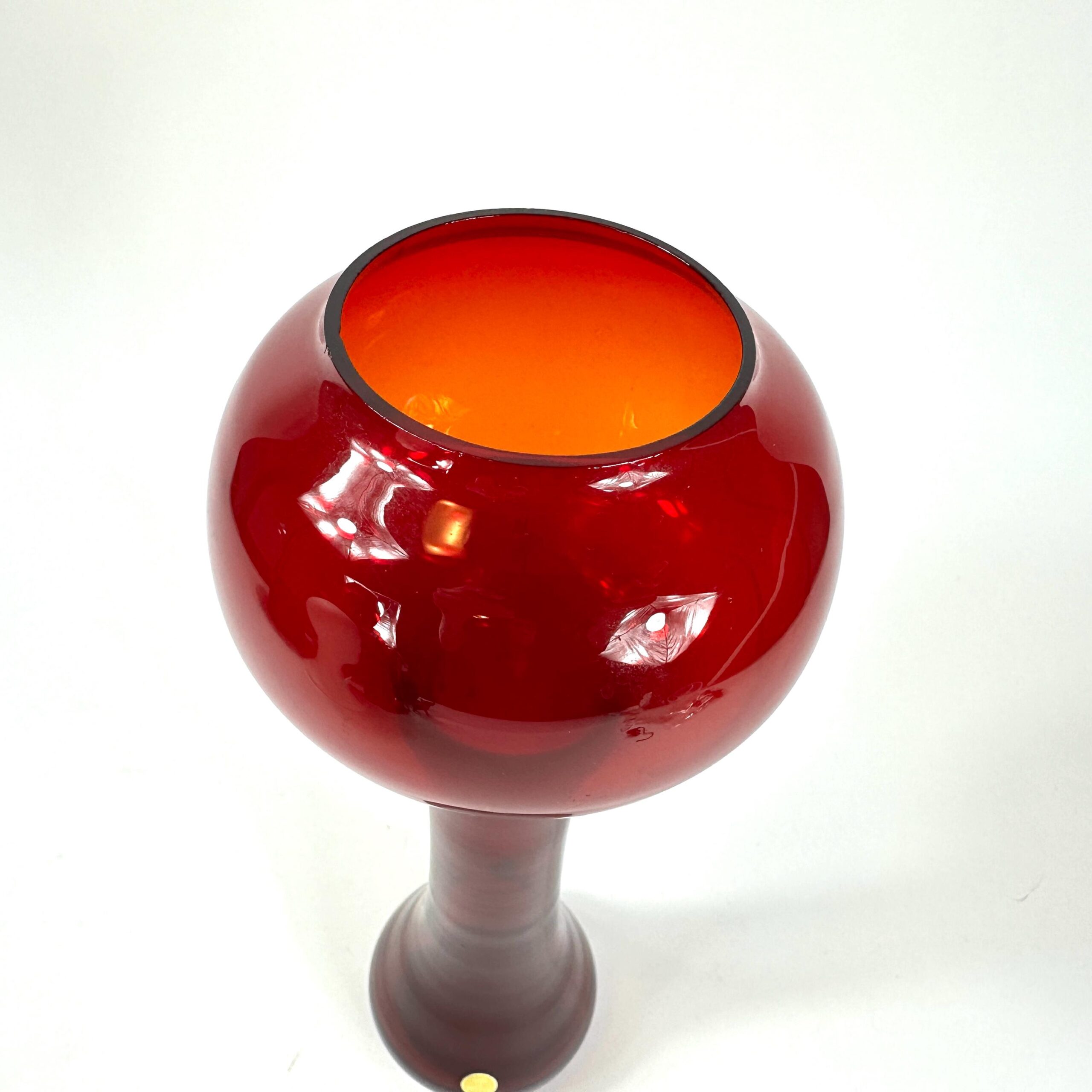 Overhead angle of Åseda vase bowl showing open rim and luminous orange interior against deep crimson glass exterior