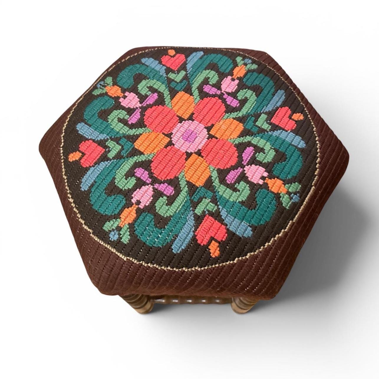 Overhead close-up of vintage needlepoint seat showing detailed floral embroidery, hand-stitched blooms in jewel tones, piping