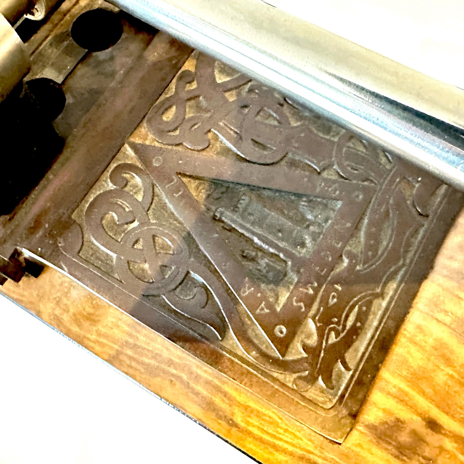 Macro shot of ornamental base plate pattern showing geometric Art Deco motifs and metal patina detail