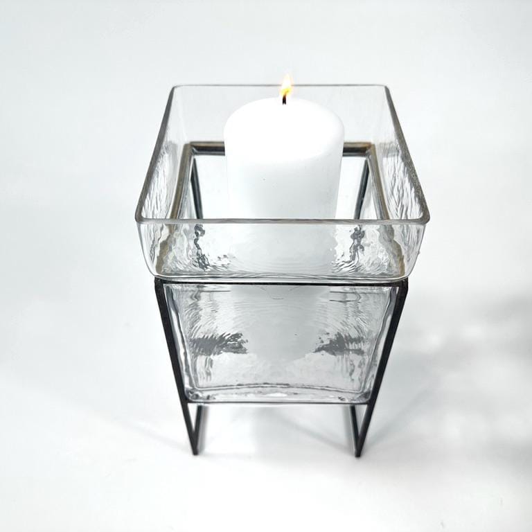 Overhead top-down view of square glass candleholder platform with candle holder visible at center, iron frame perimeter