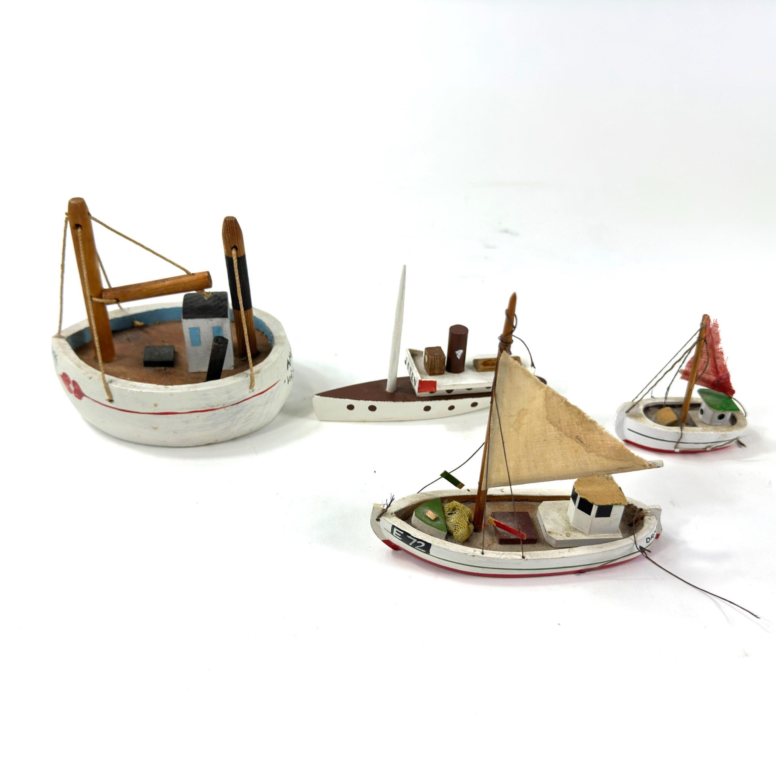 Overhead view of wooden sailboat collection showing varied boat styles and interior cabin details from above