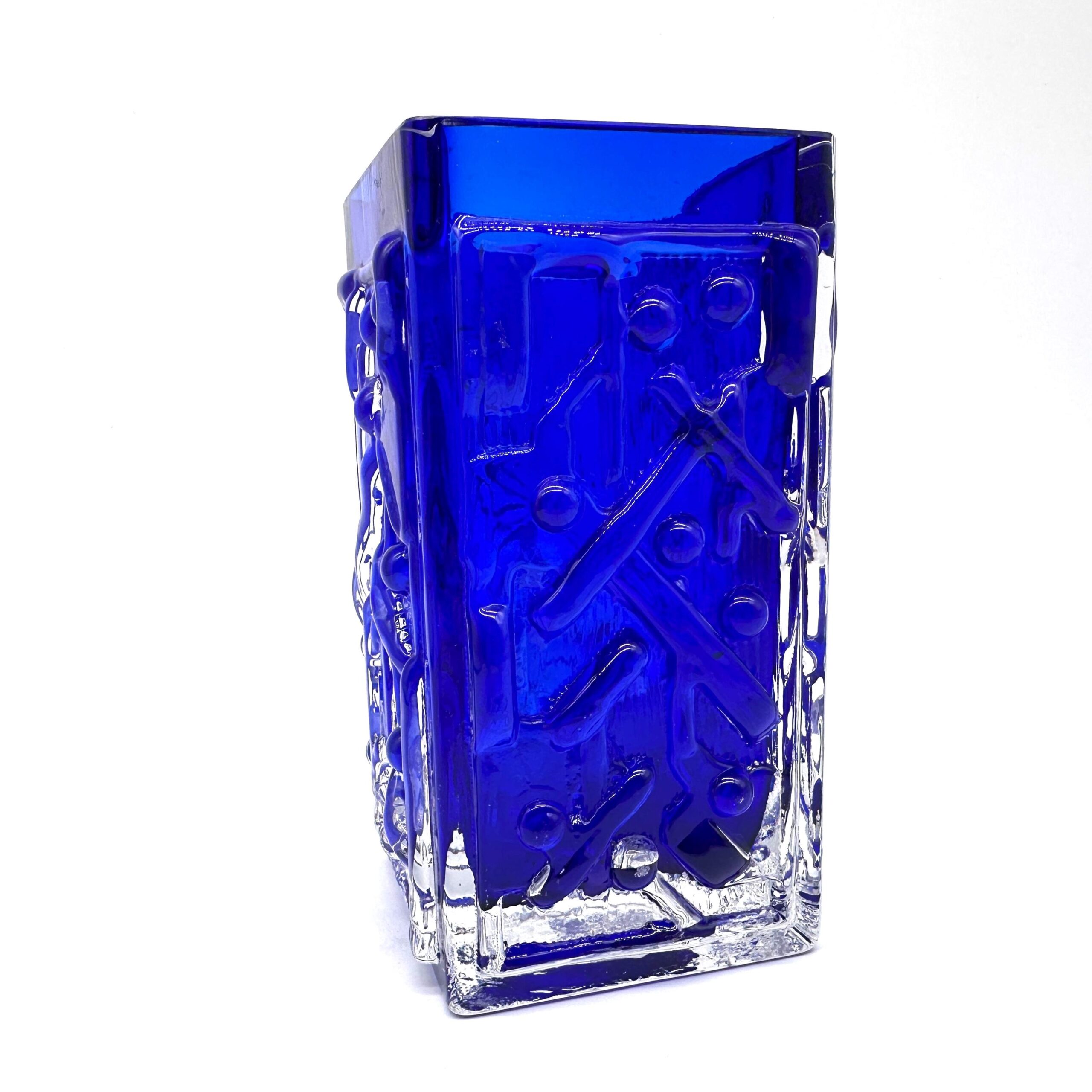 Side angle of blue art glass vase showing textured relief pattern, vertical proportions, and how light penetrates the cobalt