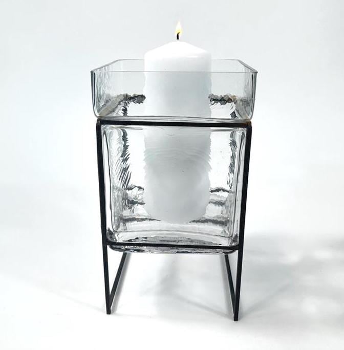 Straight-on front angle highlighting vertical glass panel texture and centered white pillar candle holder mounted on iron fra
