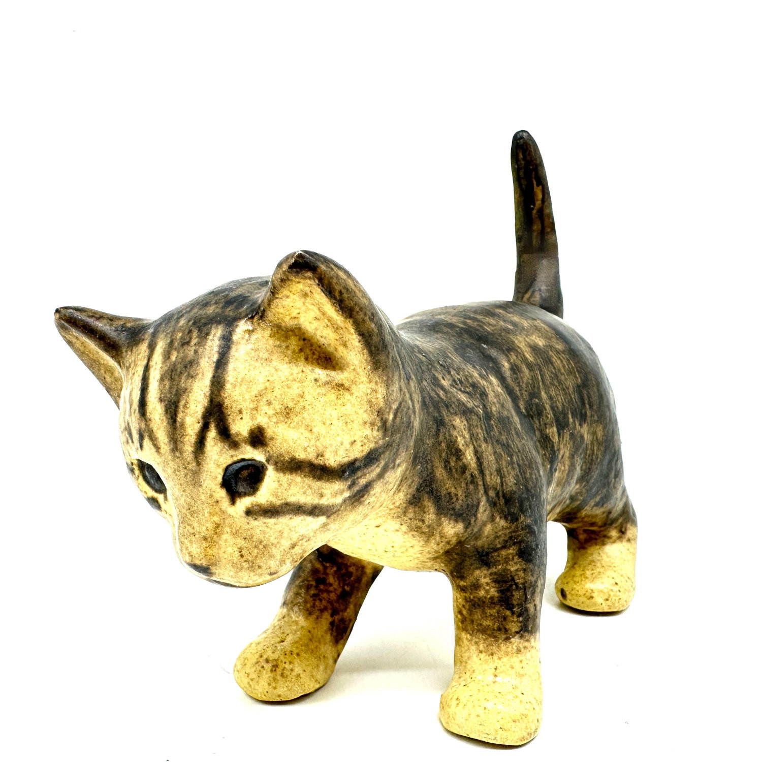 Studio pottery cat viewed from above showing tabby glaze pattern across back, head details, and tail position