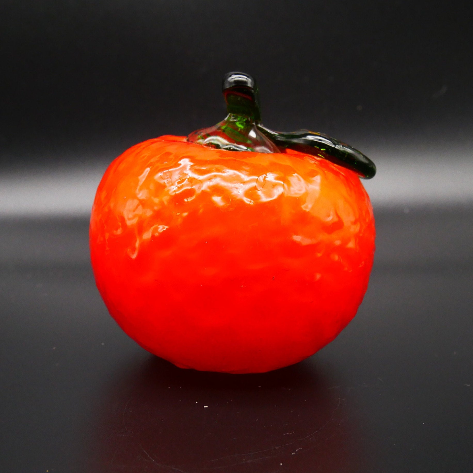 Swedish art glass orange viewed from upper angle with stem prominent, smooth rounded form clearly visible