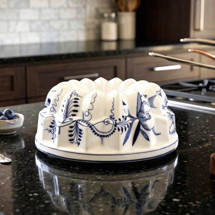 Swedish ceramic baking mold, blue and white botanical design, 23cm wide, displayed on dark kitchen counter