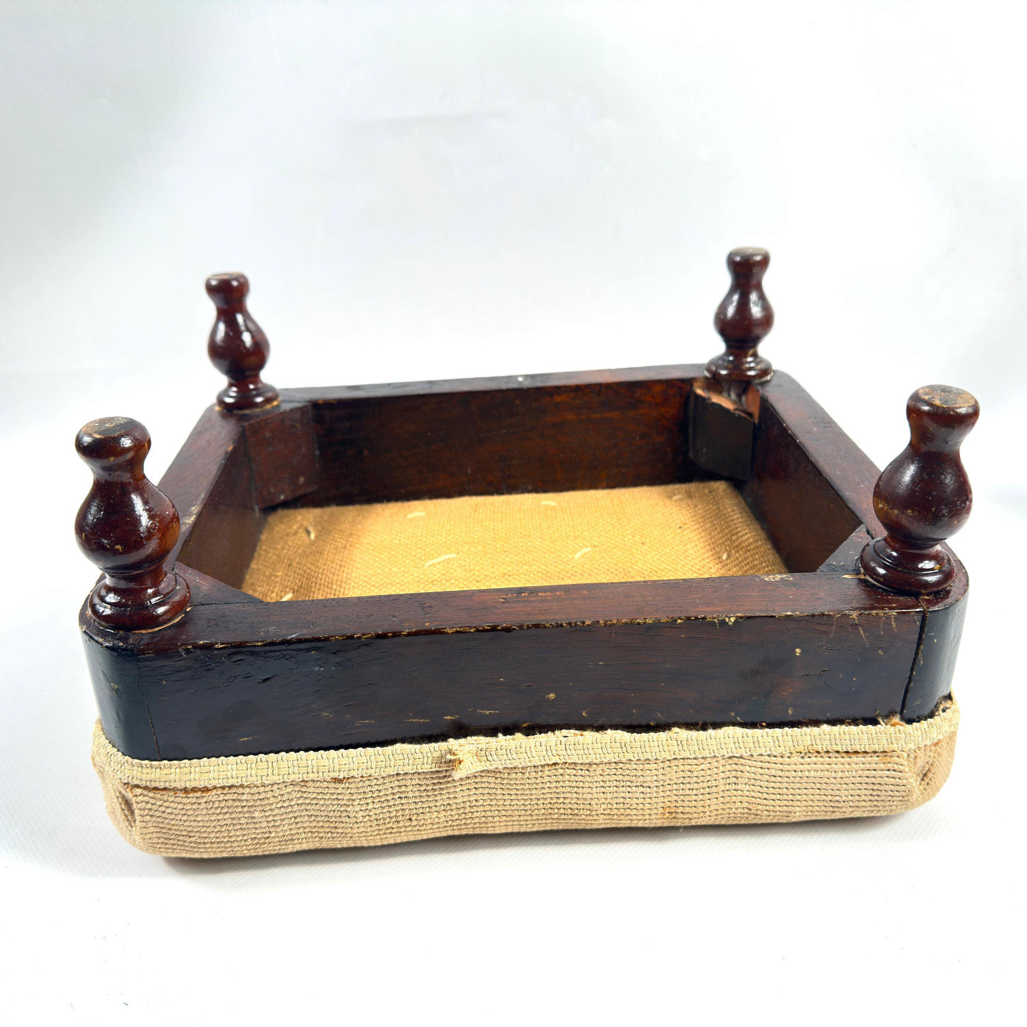 Underside detail showing turned wooden corner posts with decorative finials and wooden frame joinery work