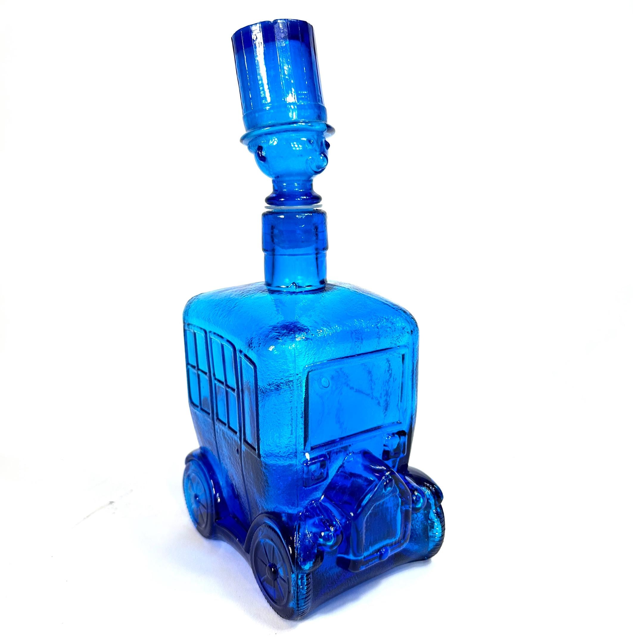 Vintage Empoli Italian blue glass bus decanter with molded cab body and driver figure stopper wearing top hat, front three-qu