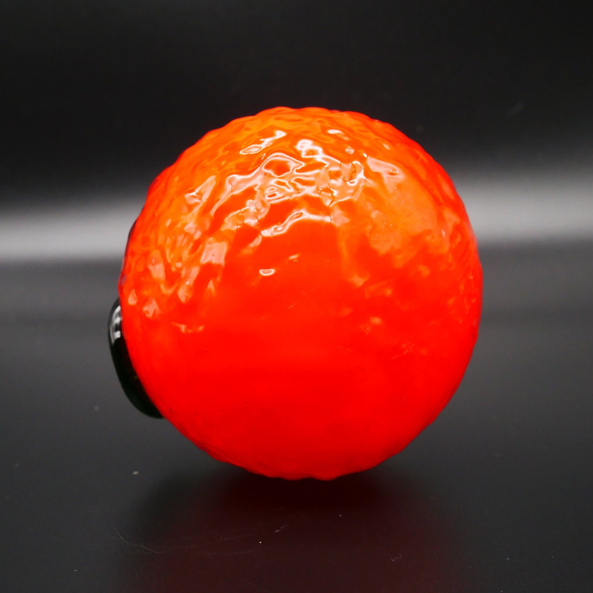 Vintage glass orange without stem showing smooth bottom surface and brilliant saturated orange tone throughout