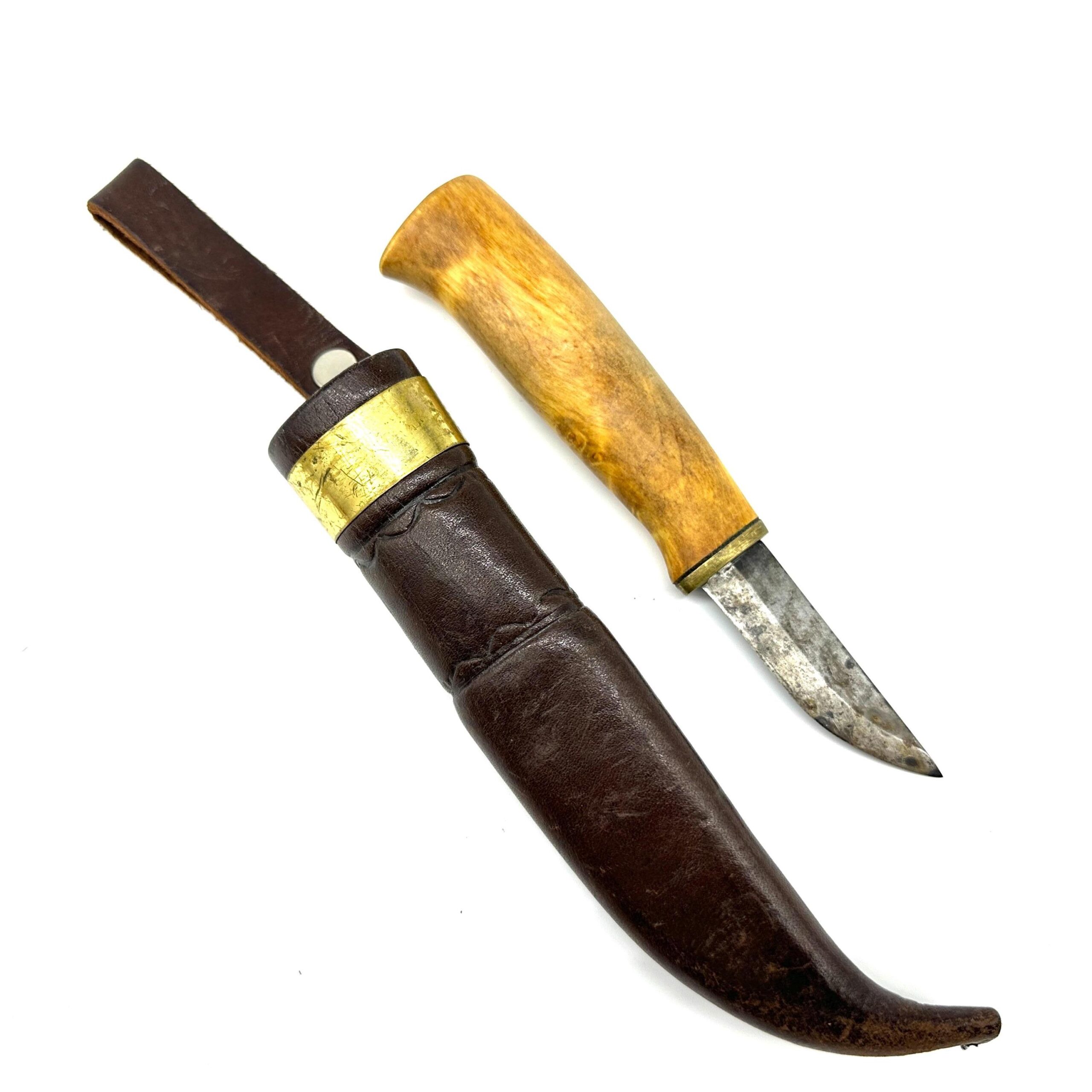 Vintage hunting knife with wood handle and brass collar beside matching leather sheath, full field kit view
