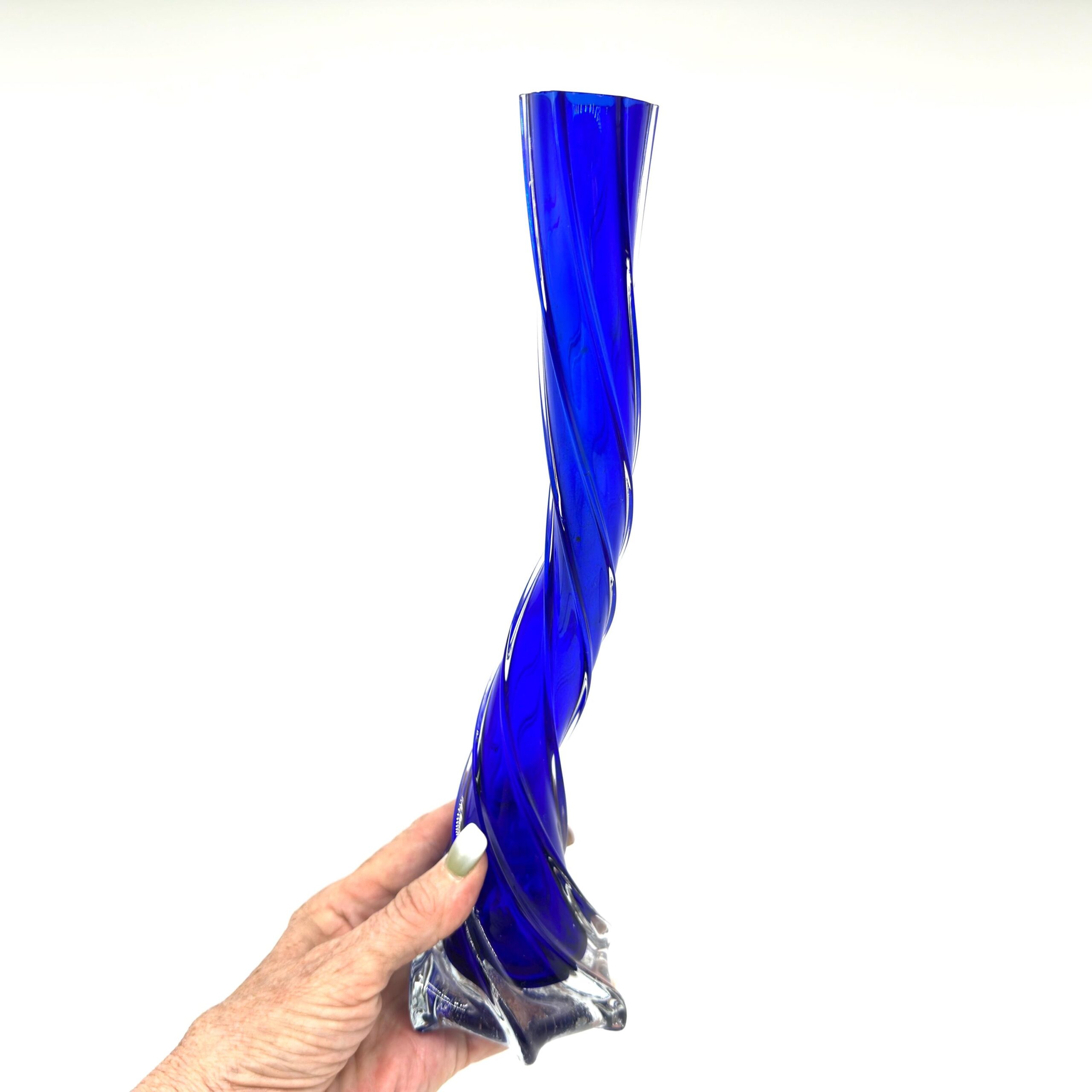 Vintage Scandinavian cobalt blue twisted glass vase held in hand, showing spiral form and clear sculptured base