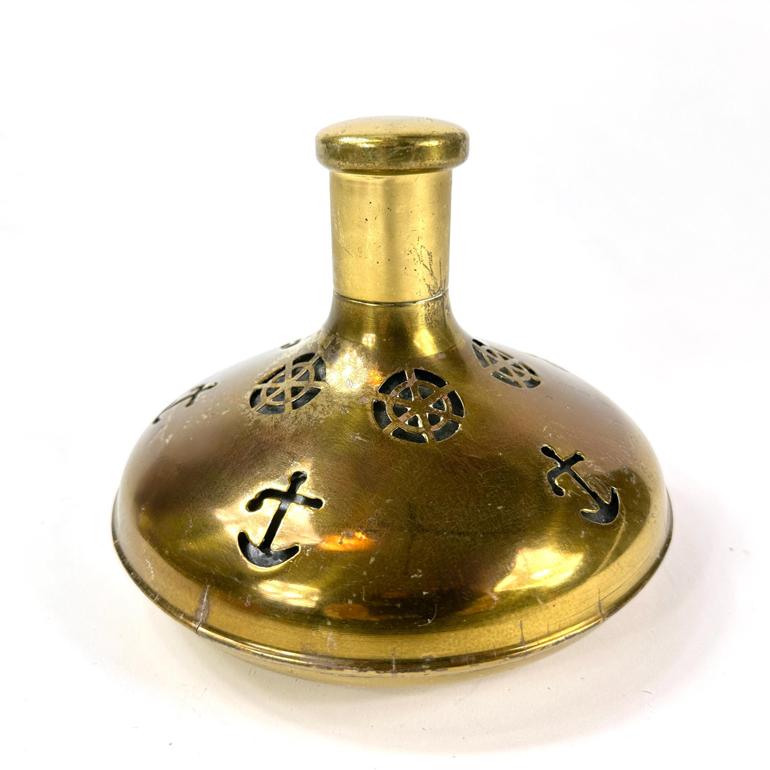 Vintage Swedish brass captain's bottle with pierced anchor and ship wheel motifs, polished golden finish, wide stable base