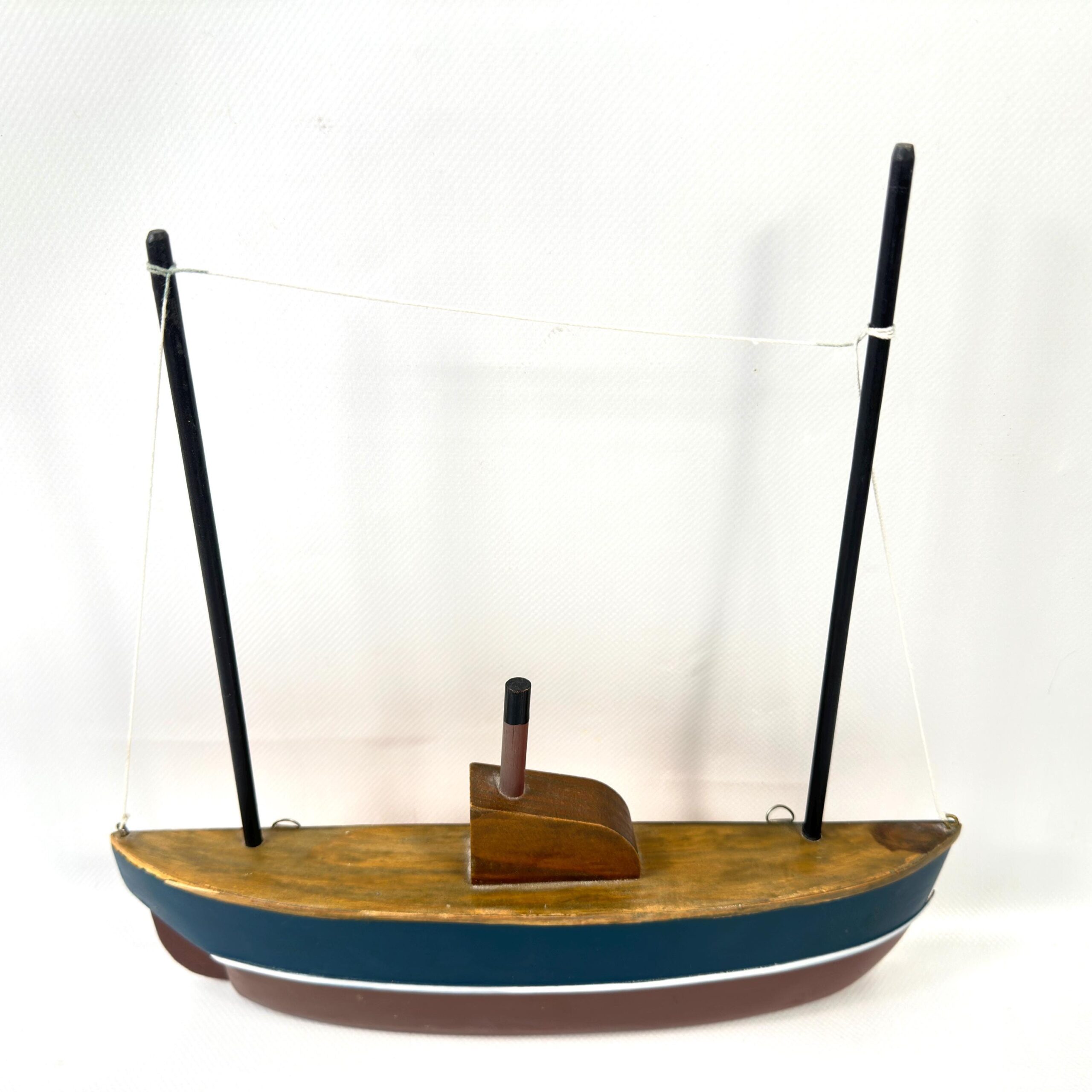 Vintage wooden sailboat hull model with dual masts, navy and burgundy painted stripes, minimalist cabin