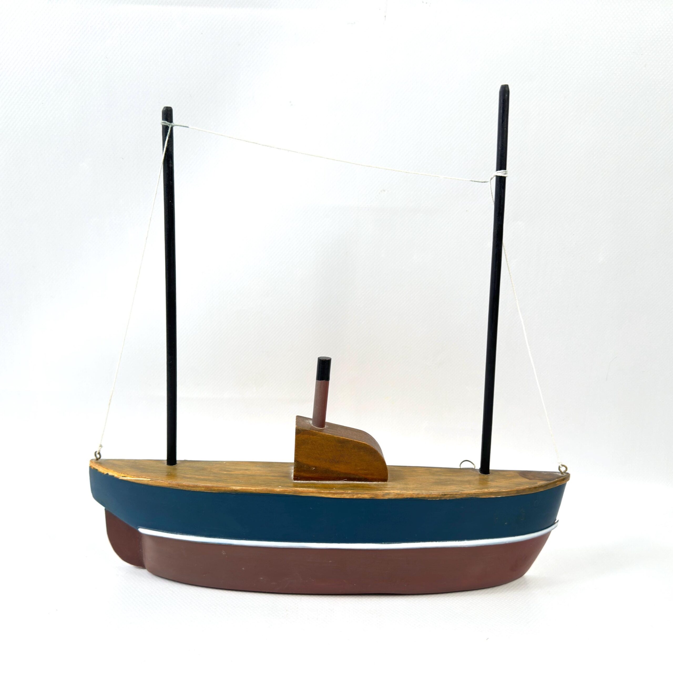 Wooden sailboat half-hull, navy and burgundy painted hull, canvas rigging, frontal centered composition