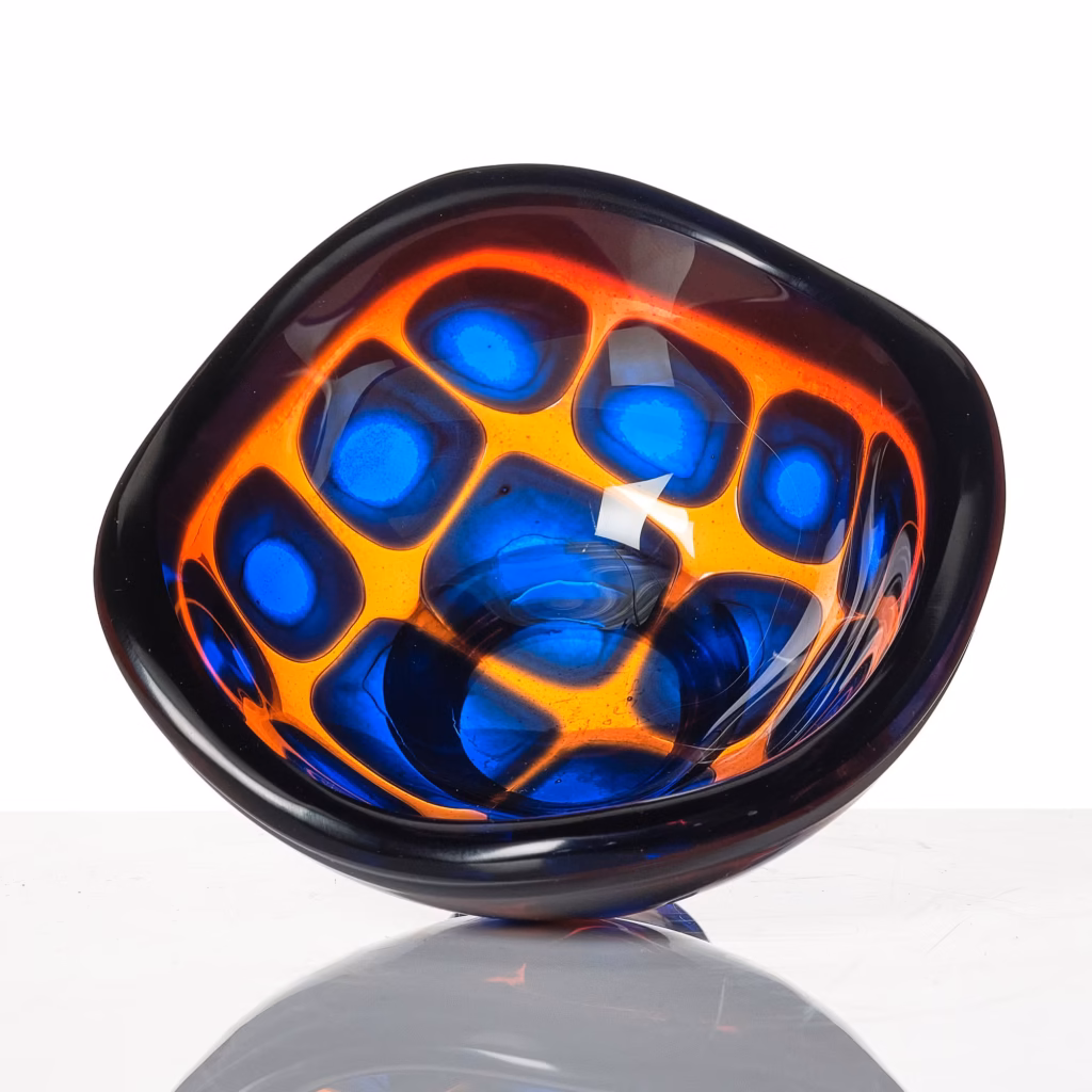 Decorative glass vessel with rounded belly and narrow neck, featuring blue rim and complex purple and blue scale-like pattern