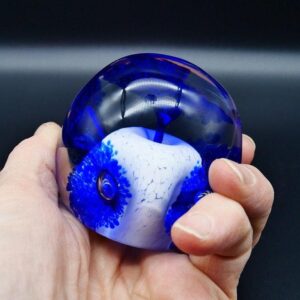 Haverud Swedish art glass paperweight held in hand, deep blue flowers with white swirls, mid-century design