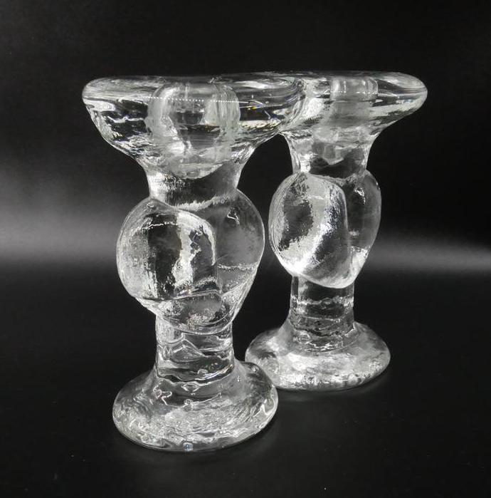 Angled three-quarter view of Swedish crystal candleholders showing textured surfaces, heart details, and candle well depth