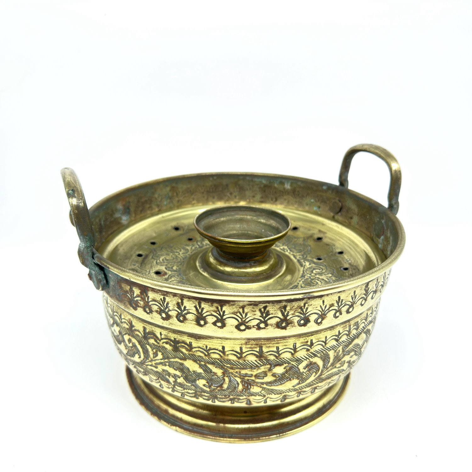 Basin interior view revealing punched decorative motif centered, with dual curved handles and smooth aging patina visible