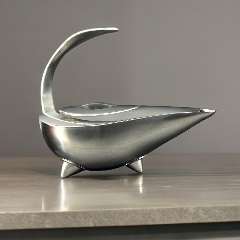 Bodum Aladdin chrome teapot by Carsten Jørgensen, full profile view showing sculptural form and curved handle
