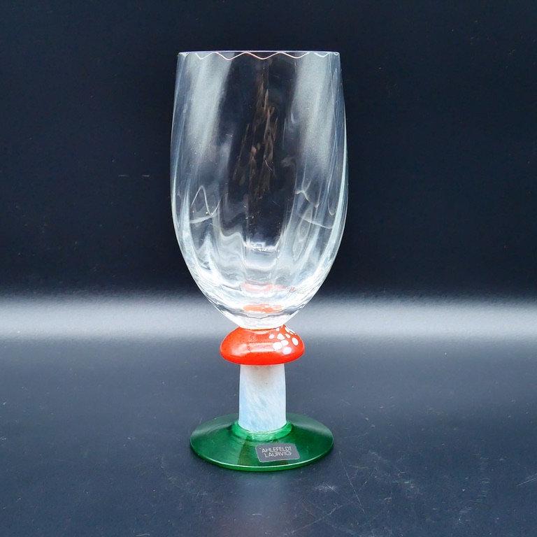 Centered view of crystal champagne flute with mushroom stem, showcasing symmetrical design and proportions