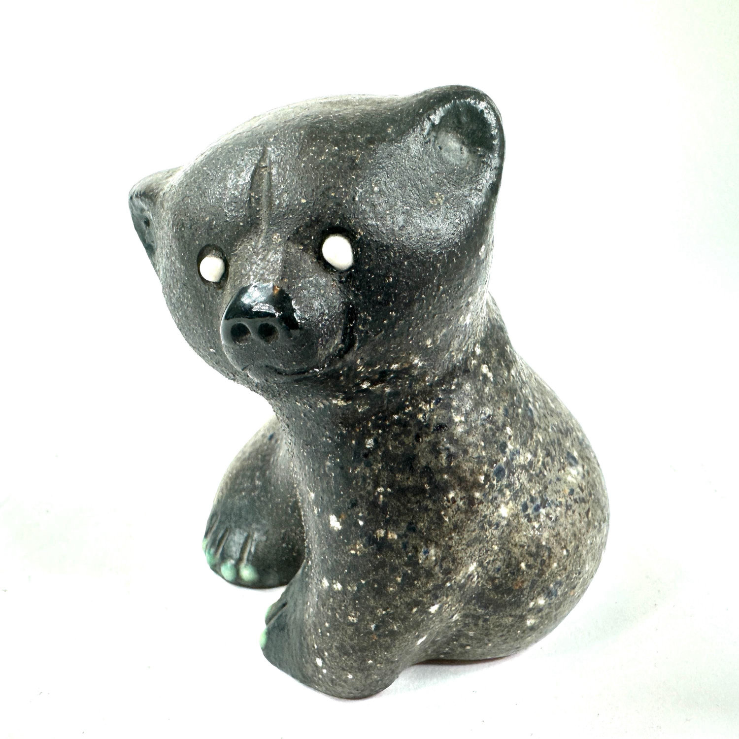 Ceramic bear figurine tilted view showing rounded posterior, articulated back legs, paw coloring, and overall compact sculptu