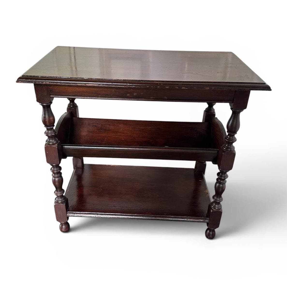 Dark wood end table featuring turned leg supports, open shelving system, book storage, timeless design