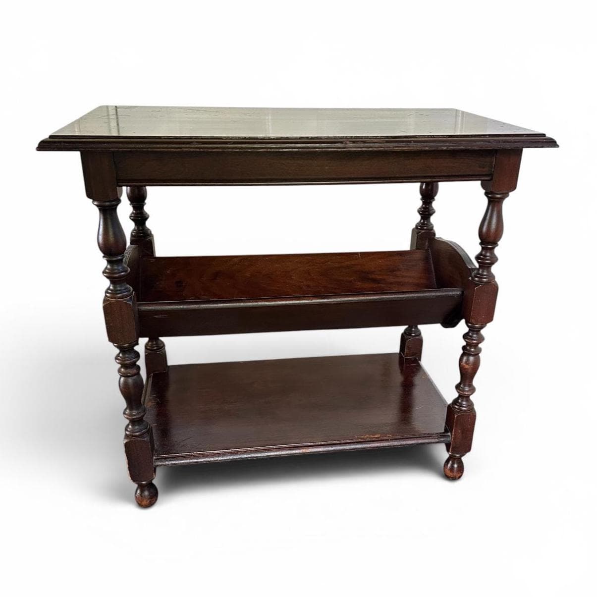 Dark wood end table with three open shelves, turned legs, and glass top, architectural front angle