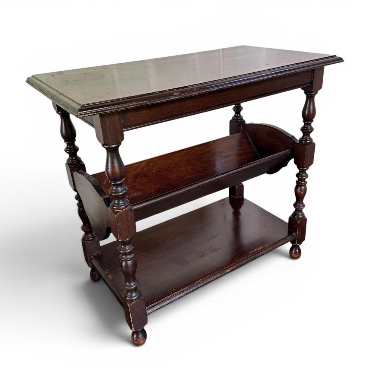 Dark wood end table with two shelves and graceful turned support legs, clean three-quarter angle view