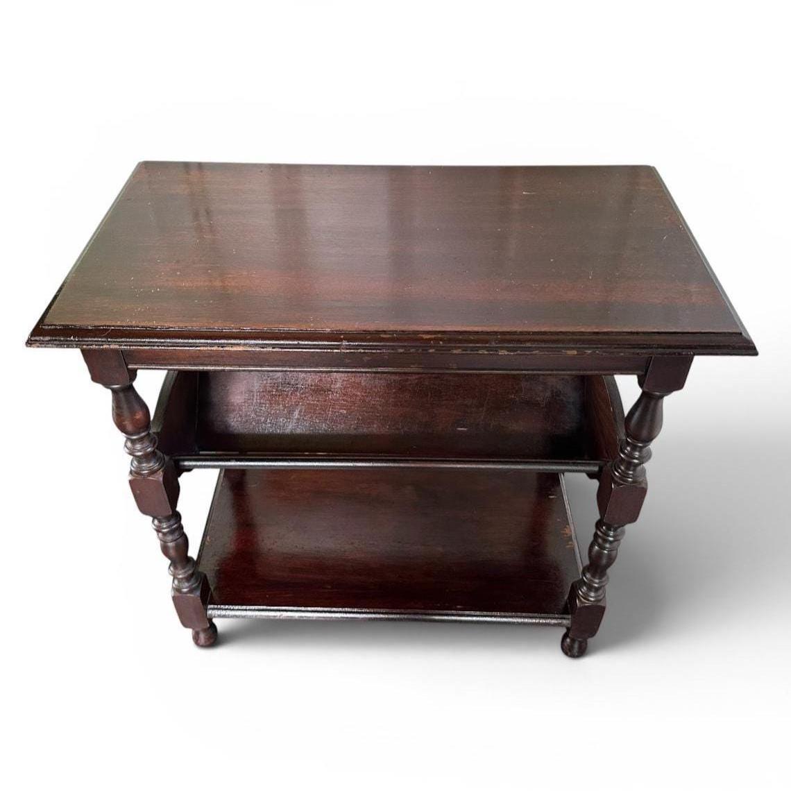 Dark wood vintage side table with book rack shelf, three storage tiers, turned spindle legs, finished view
