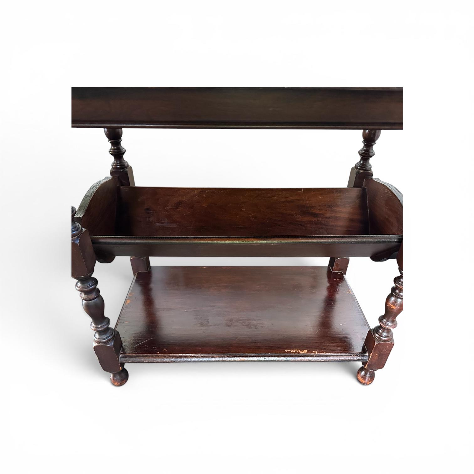 Front-facing dark wood side table showing dual open shelves and turned leg supports, minimal white background