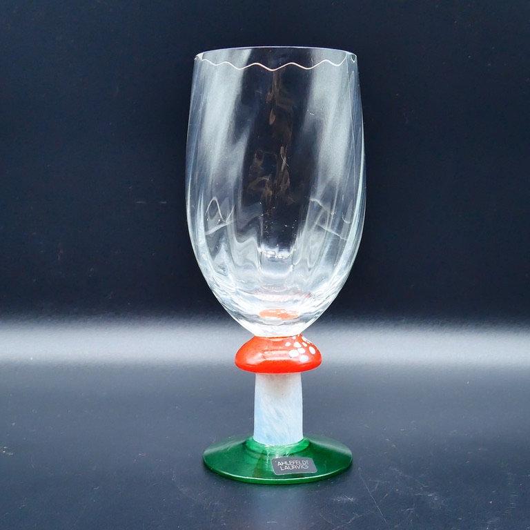 Frontal view of crystal flute highlighting transparent glass quality, mushroom stem, and deep green pedestal base