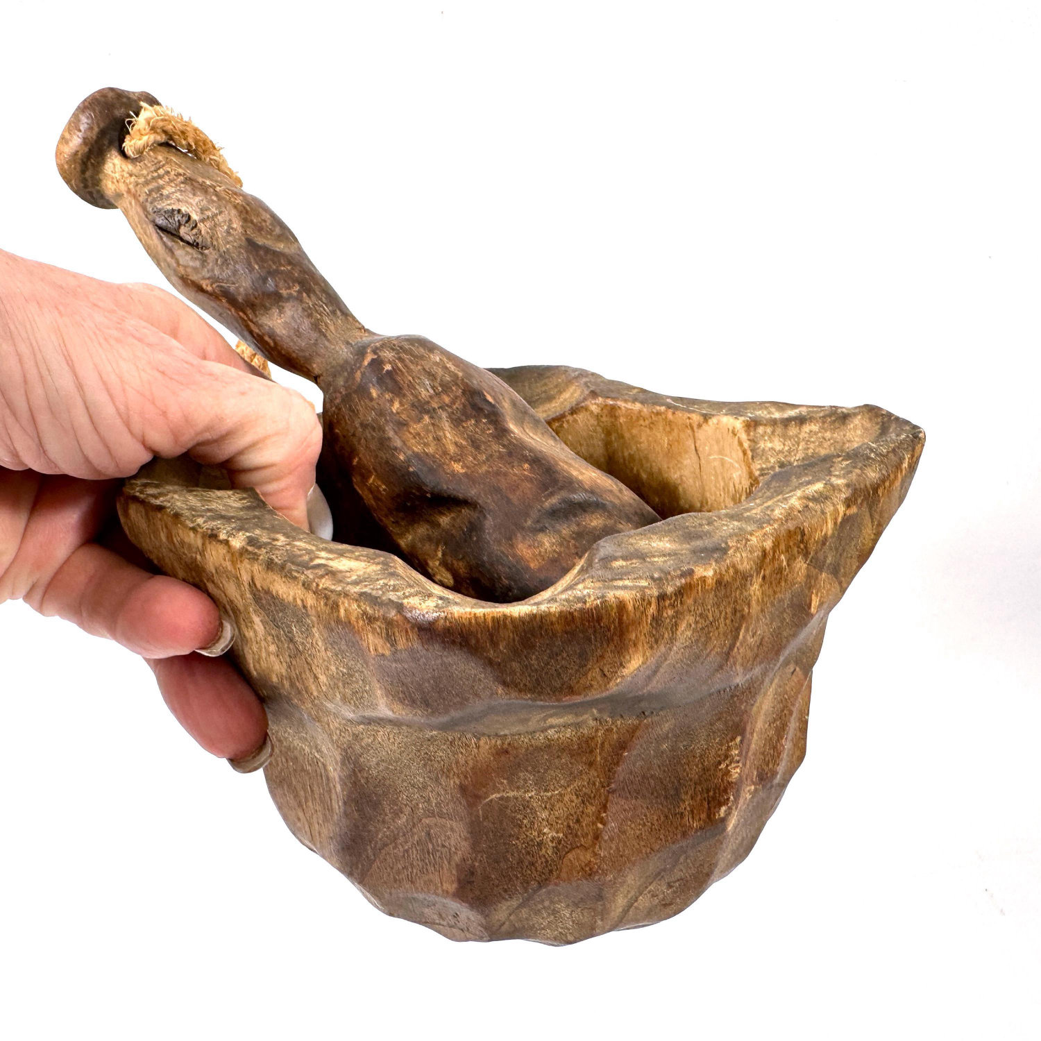 Hand-carved Scandinavian wood mortar and pestle with rich patina, faceted bowl, and rope-looped pestle held in palm