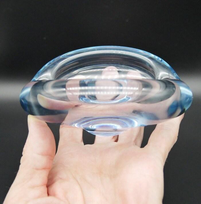 Holmegaard crystal bowl cradled in hands showing tactile quality and ice-blue glow against skin tone