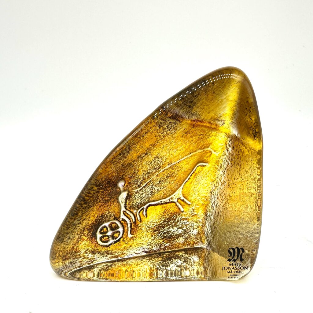 Golden amber glass sculptural form with organic, curved profile suggesting abstract animal or natural form.