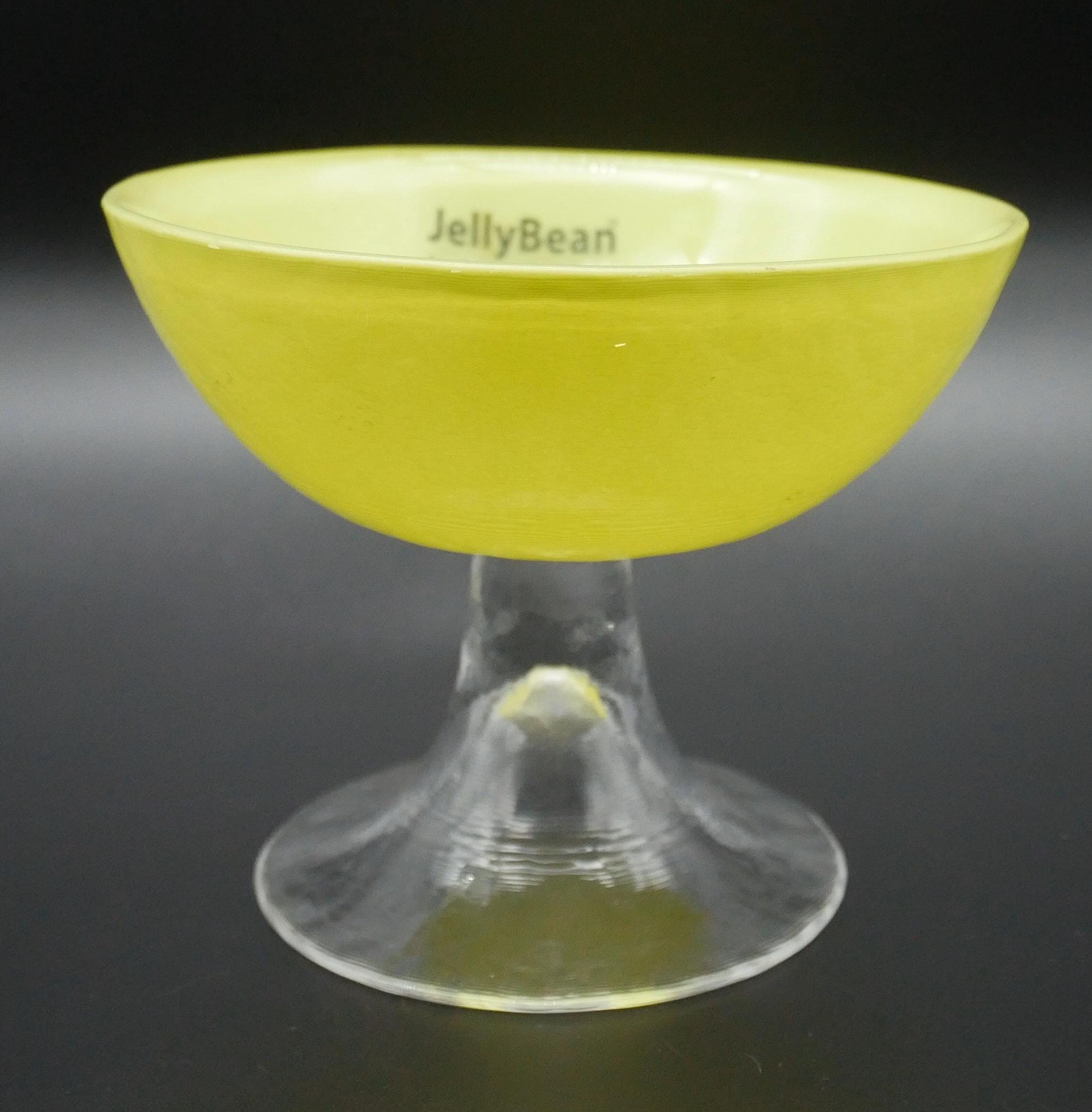 JellyBean yellow glass bowl with clear pedestal foot, angled view showing bright chartreuse bowl and transparent stem base