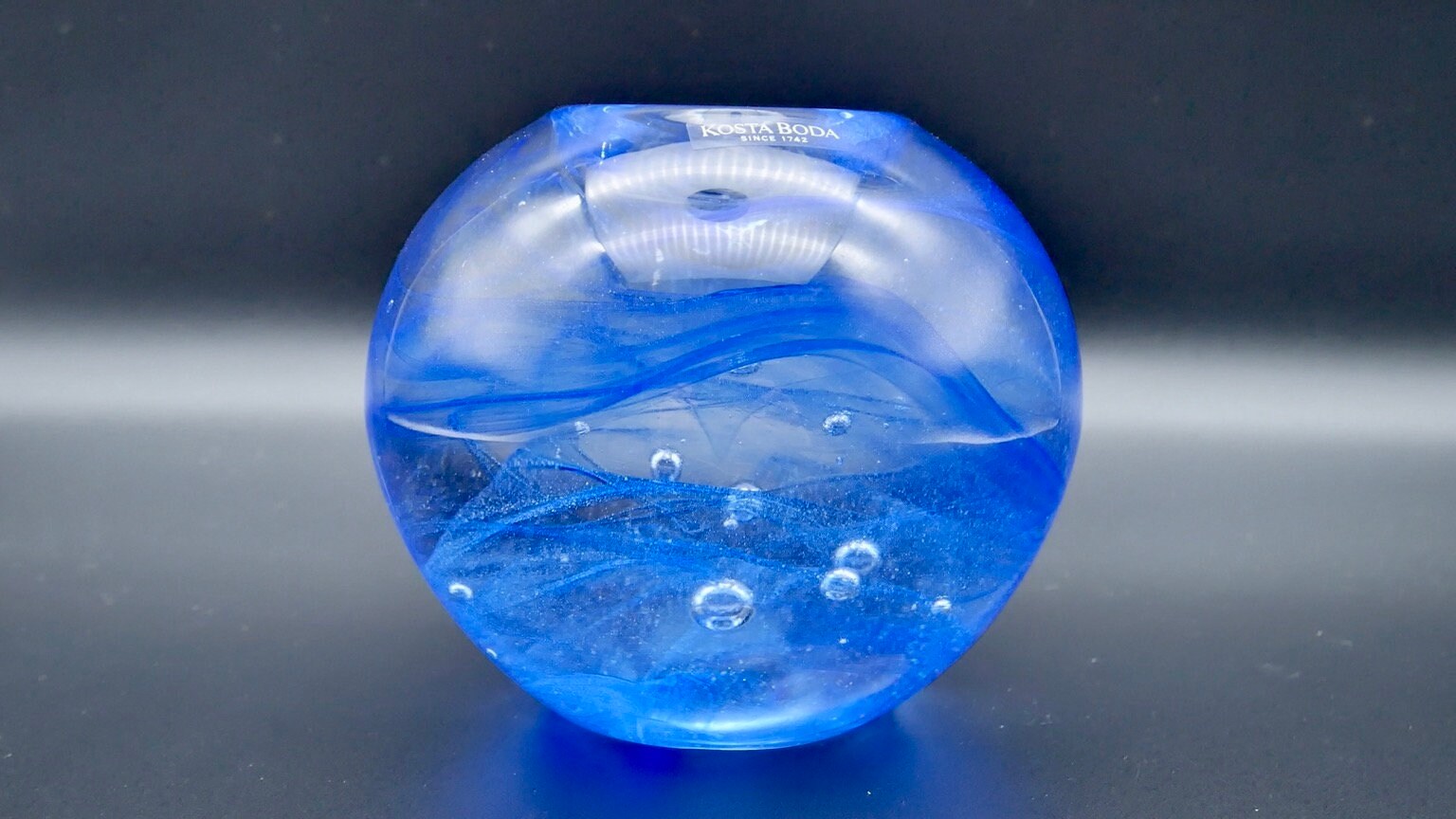 Kosta Boda cobalt blue art glass sphere, hand-blown mid-century candleholder with suspended air bubbles, front view