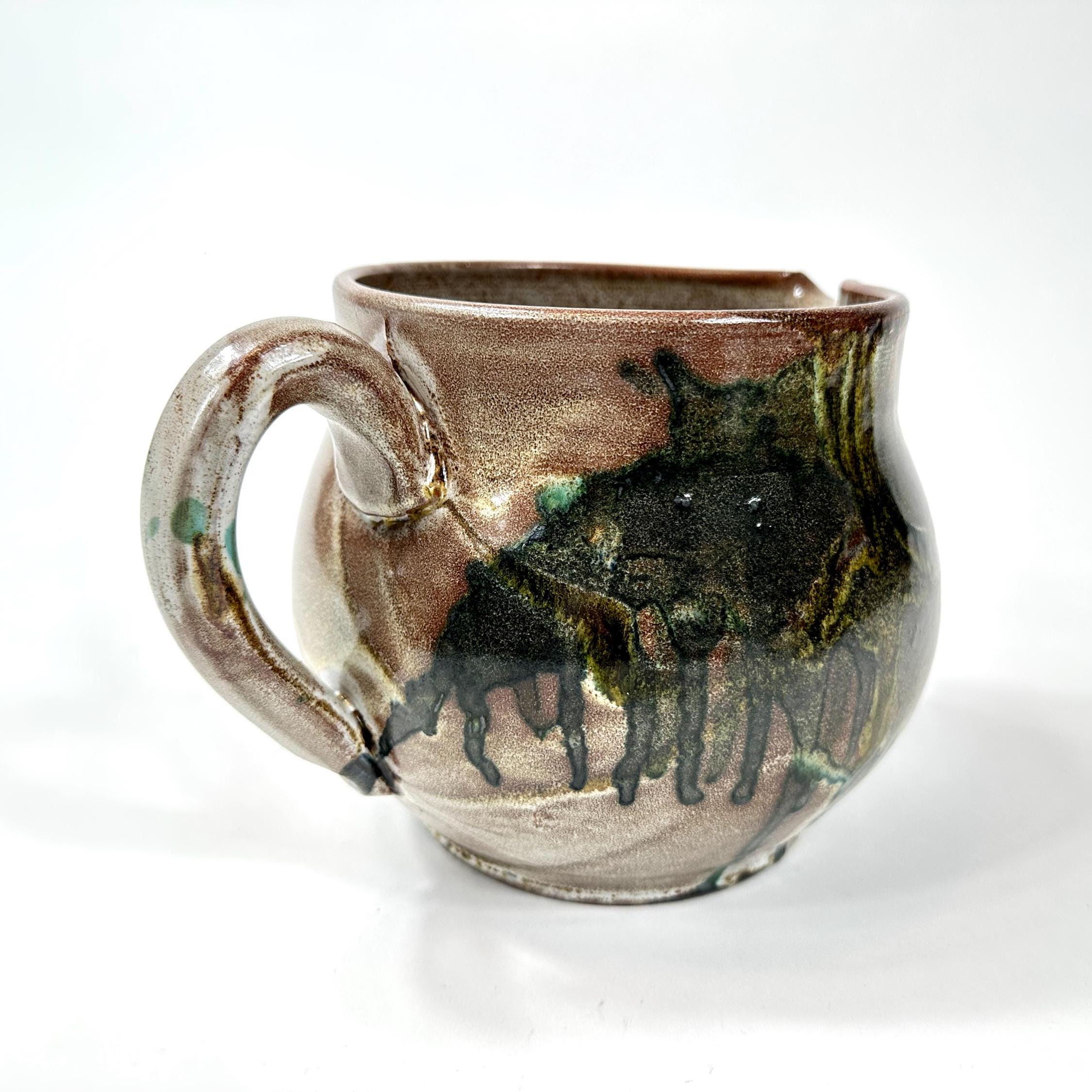 Pottery jug side view displaying full silhouette, curved handle anatomy, and mid-body glaze concentration