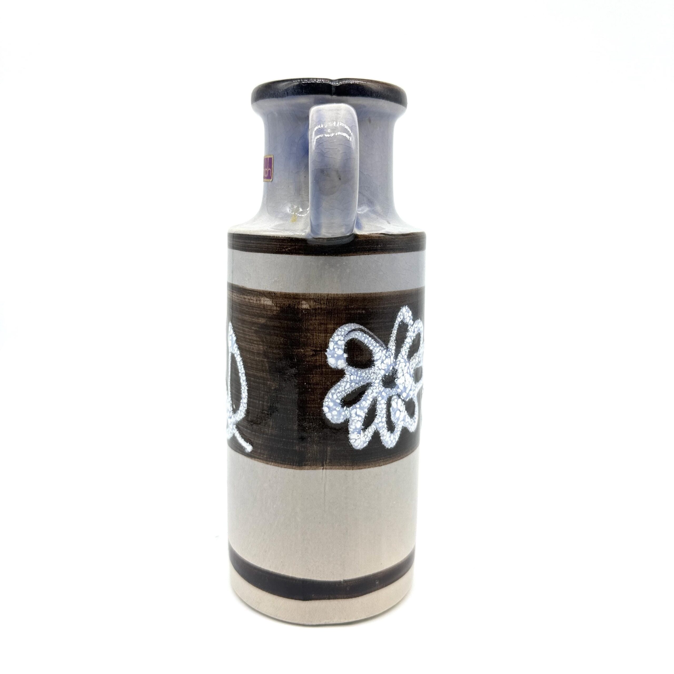 Rotated perspective of vintage fat lava vase highlighting white flora on brown band, cylindrical ceramic silhouette