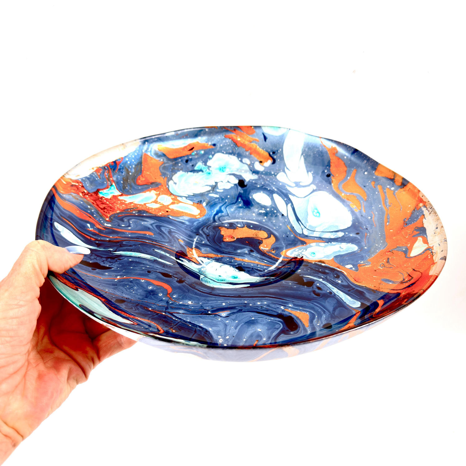 Scandinavian art glass bowl, 30.5 cm, held in hand, showing marbled deep blue, aqua, and copper orange swirled design from ab