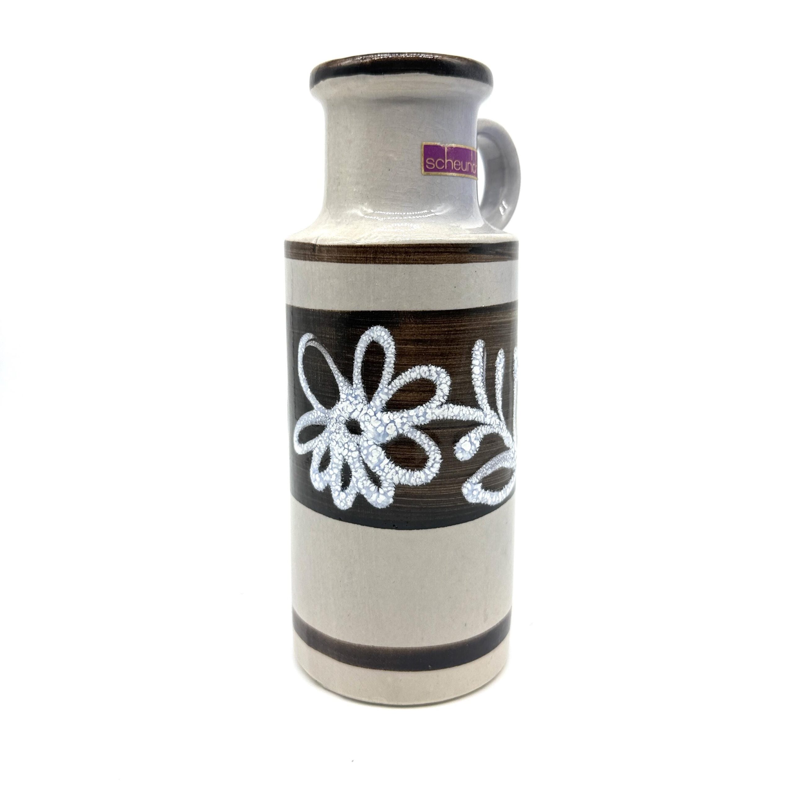 Side angle of Scheurich vase displaying white looped flowers on dark brown band, cylindrical form with contrasting glazes