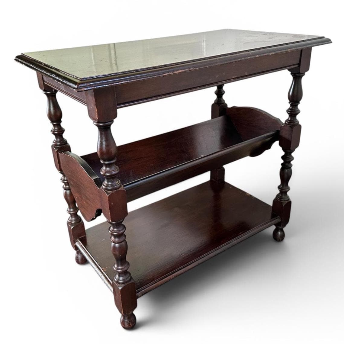 Three-shelf dark wood table with turned legs, book storage capability, full assembled view perspective