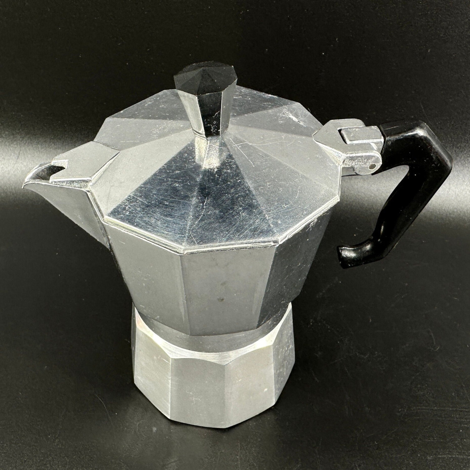 Top-down view of moka pot showing octagonal lid, steam valve, and internal chamber structure