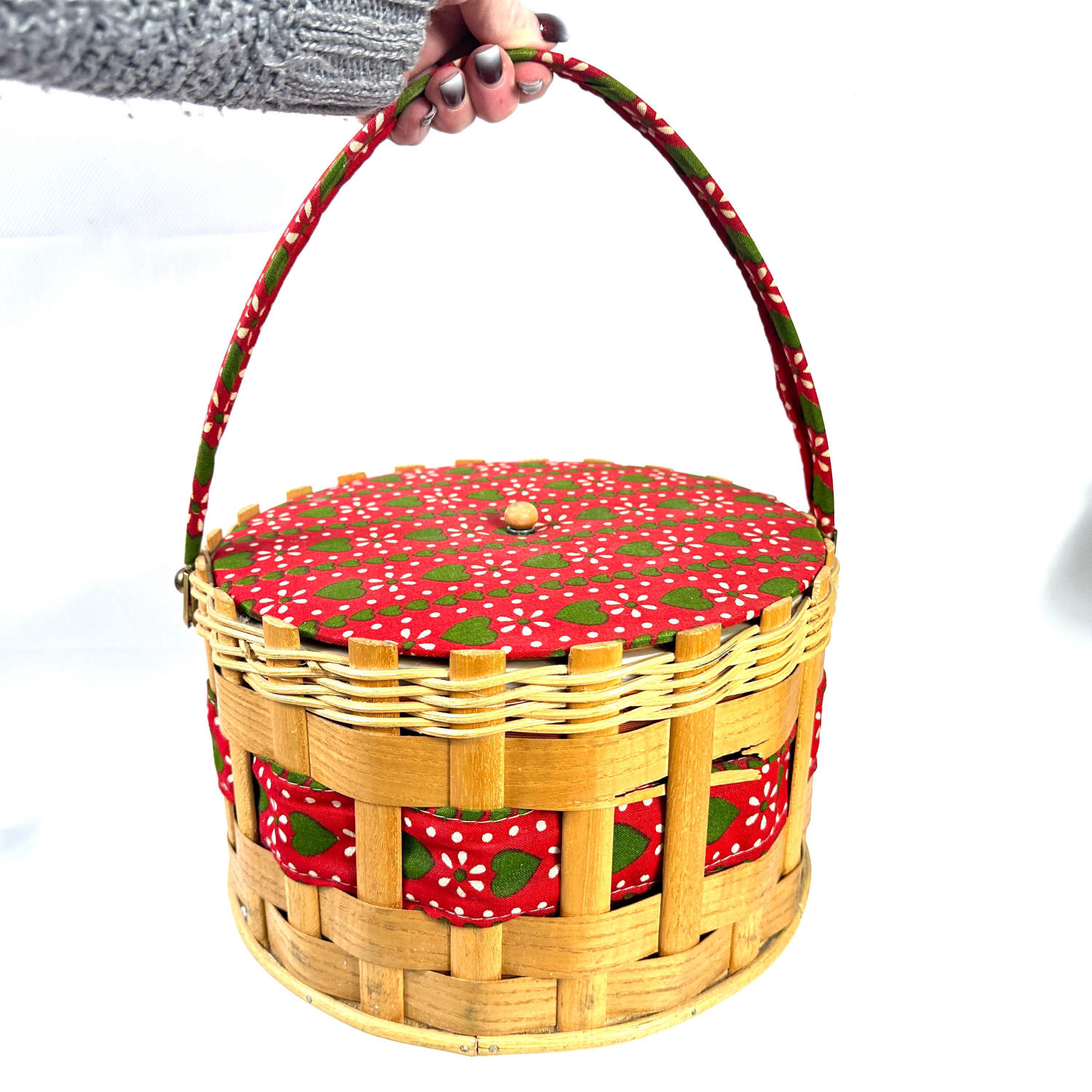 Vintage 1970s woven wood sewing basket with red fabric lid, green heart and white floral print, burgundy wrapped handle, held